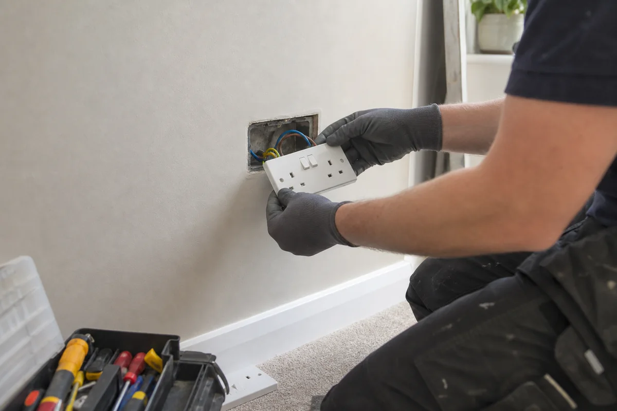 Electrician installing a double wall socket